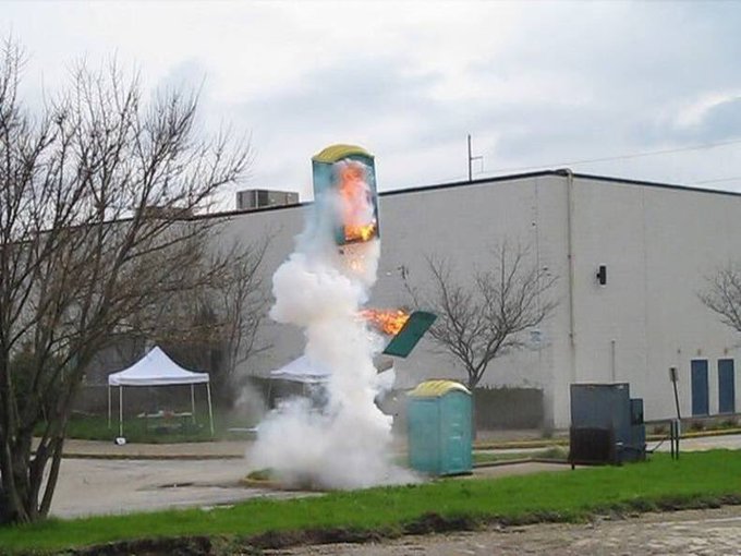 A white plume rises around a small public bin or fixture.