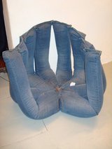 A chair is upholstered to resemble empty blue jeans.