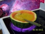 Watermelon bowl filled with yellow soup.